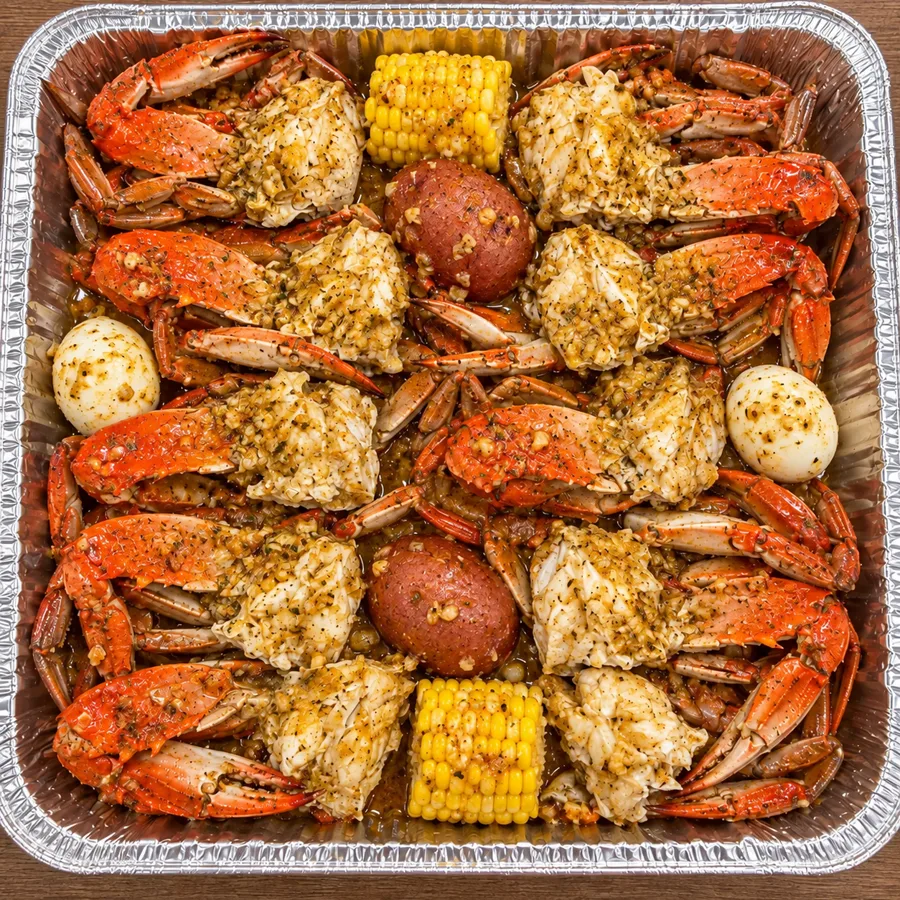 The Blue Crew with 6 steamed blue crabs broken into 12 halves in an aluminum tray